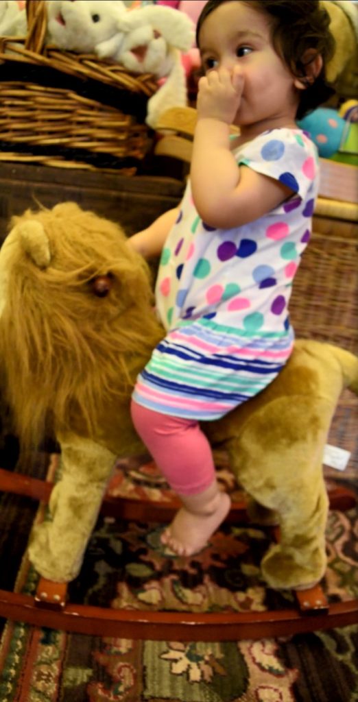 toddler girl riding on the rocking animal toy